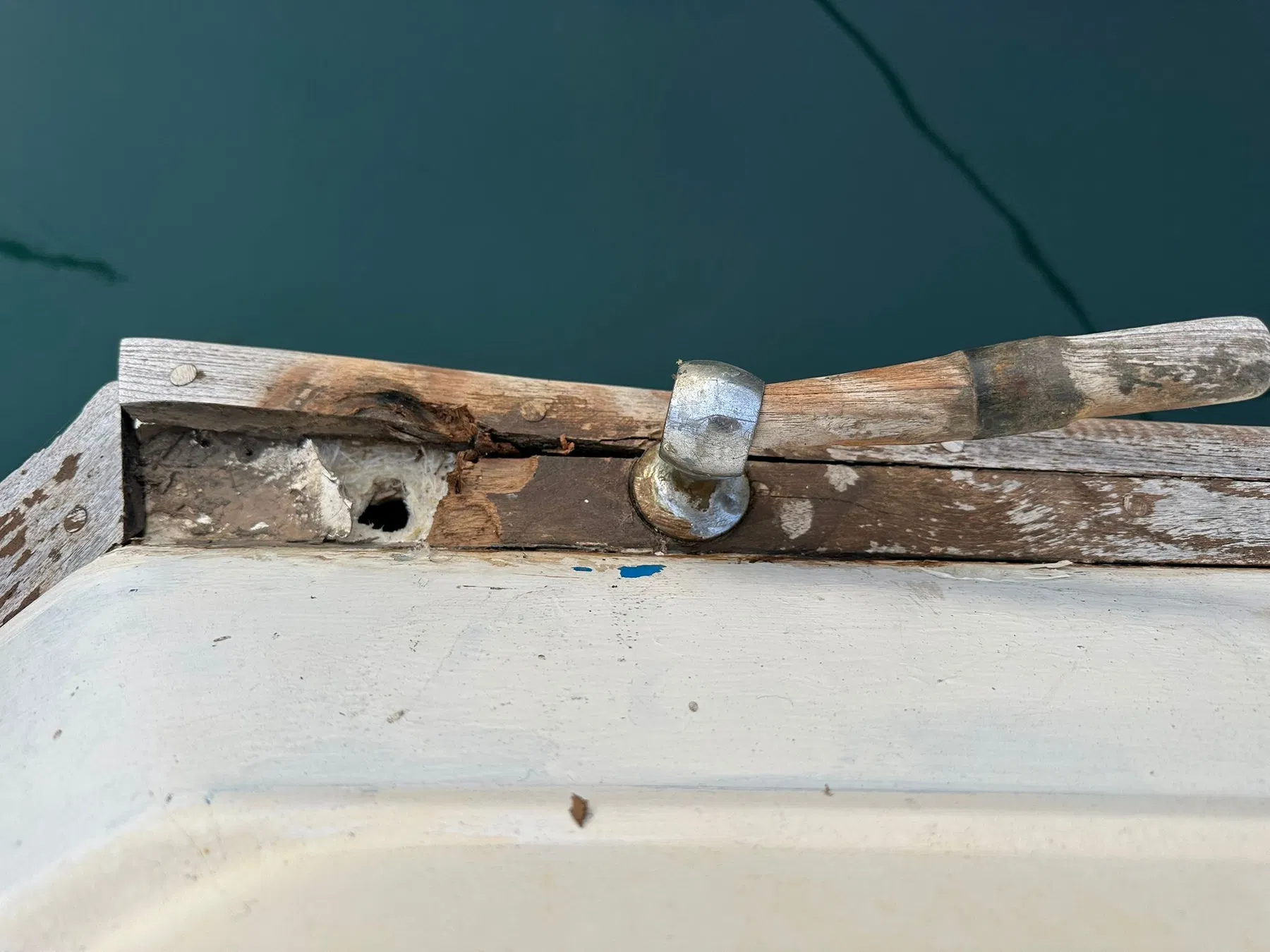 Bateau endommagé SANKARA — détail du pont arrière montrant du bois apparent, un accastillage et une ouverture dans la zone de fixation.