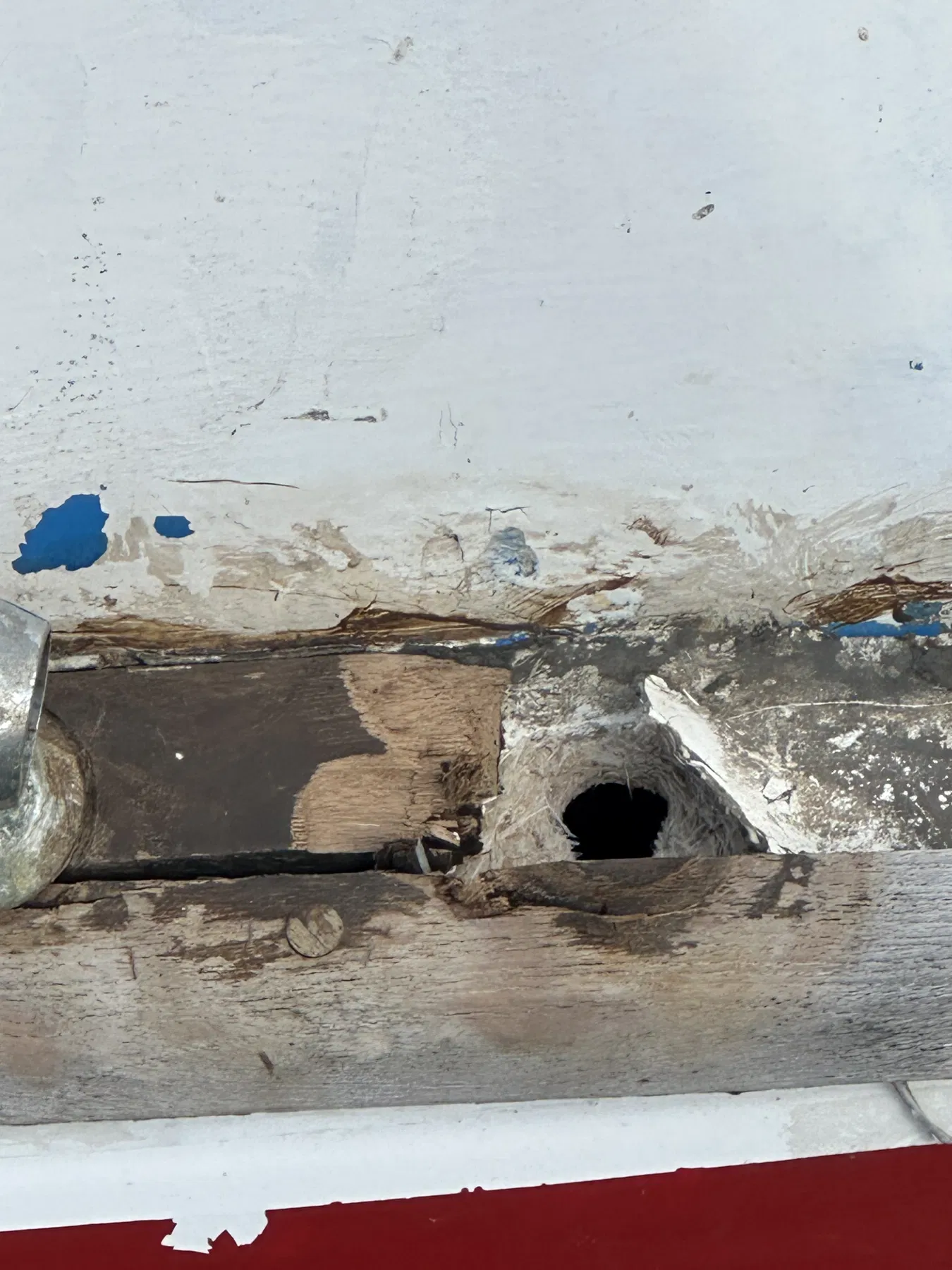 Bateau endommagé SANKARA — zone ouverte ou arrachée dans le pont arrière en bois près d’un accastillage.