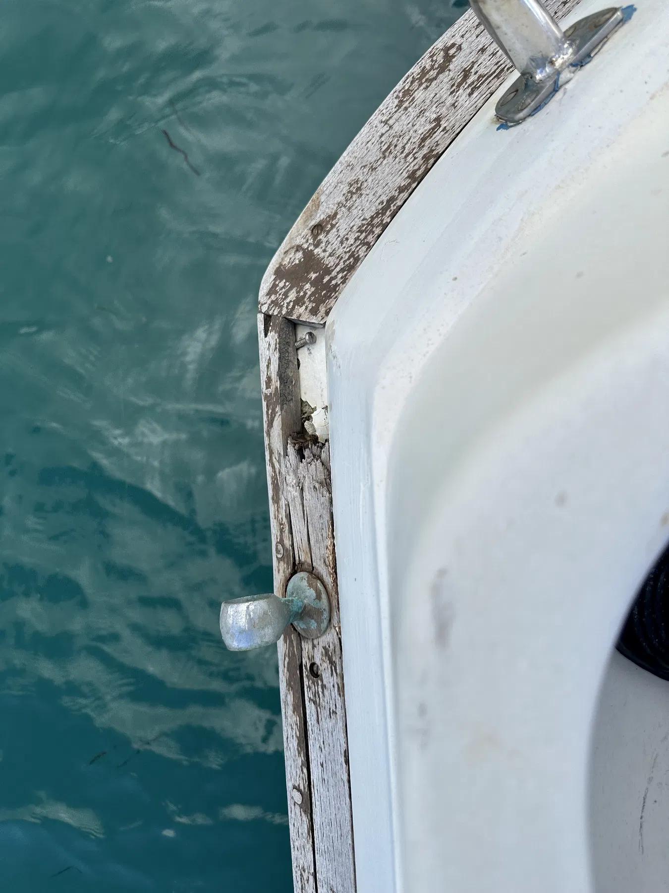 Bateau endommagé SANKARA — bord de pont avec accastillage, vis et état visible du bois.