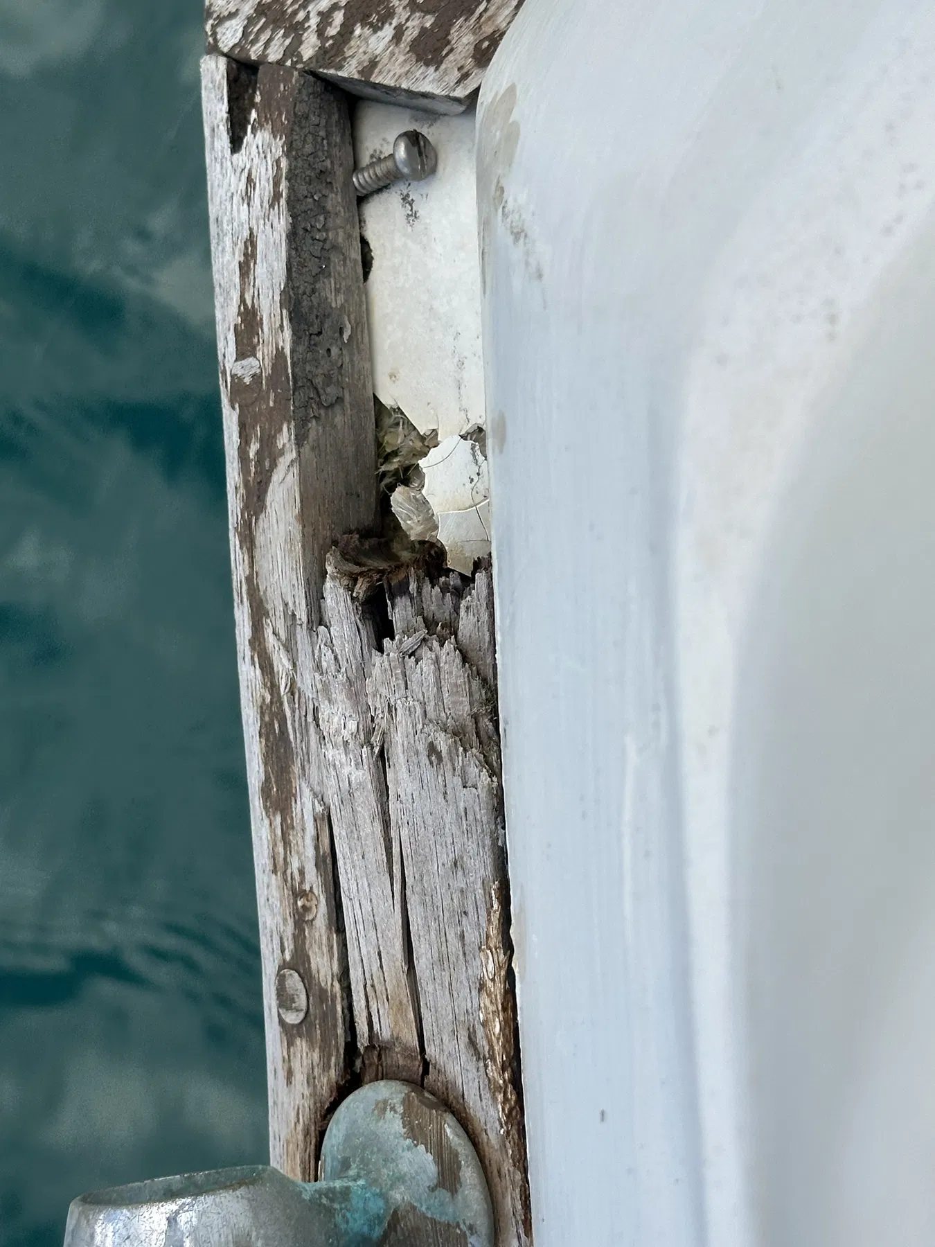Bateau endommagé SANKARA — bord en bois fortement ouvert ou fragmenté à l’arrière.