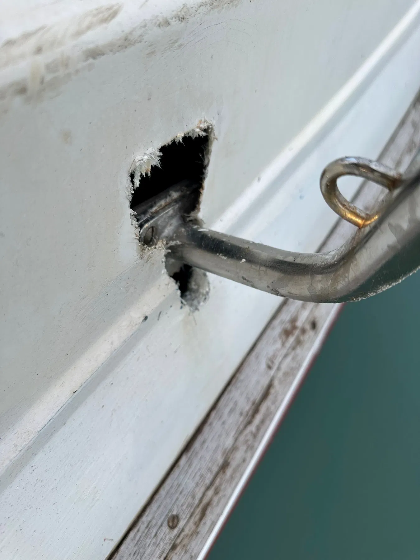 Bateau endommagé SANKARA — tube du balcon arrière dans une ouverture de la structure arrière aux bords visiblement irréguliers.