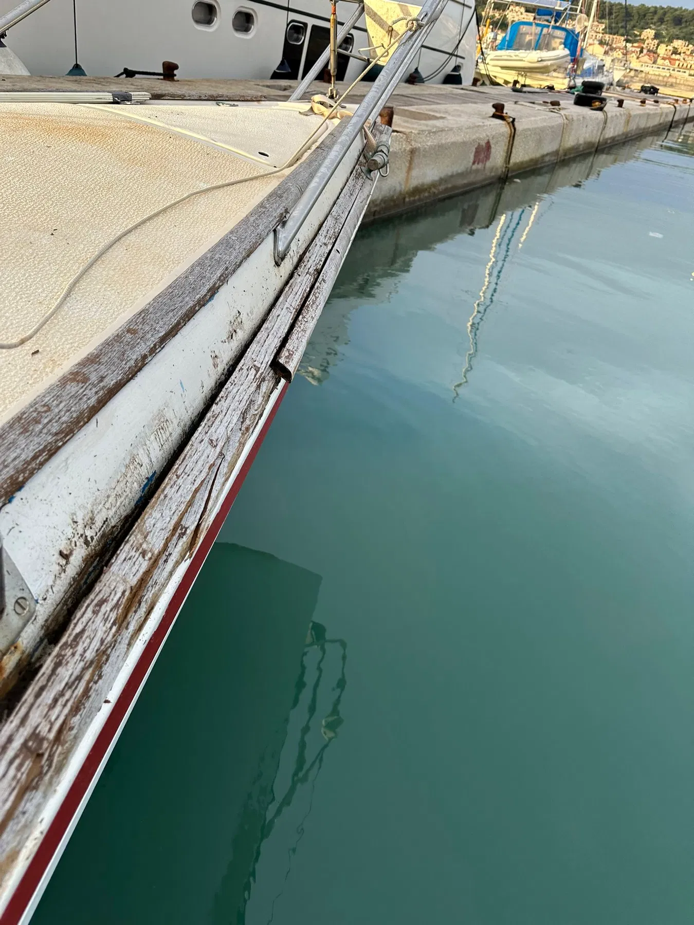 Bateau endommagé SANKARA — vue le long du bord en bois au niveau du pont ou de la partie supérieure de la coque.